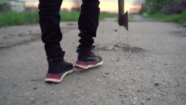 Tiener wandelingen met een bijl langs de oude weg — Stockvideo