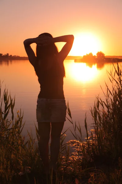 Дівчина в озері на заході сонця Стокове Зображення