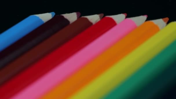 Crayons de couleur Douze pièces allongées sur une table noire — Video