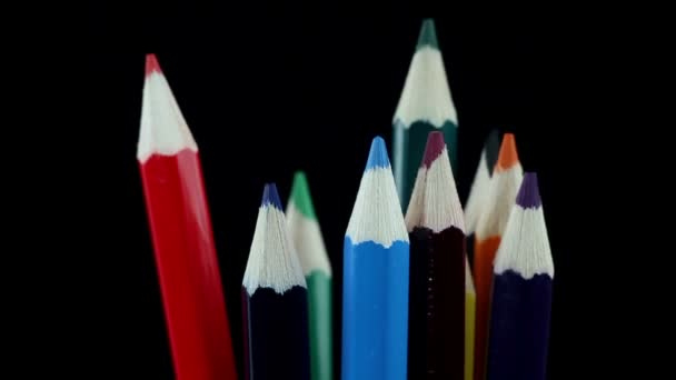 Lápices de colores giran sobre un fondo negro — Vídeos de Stock