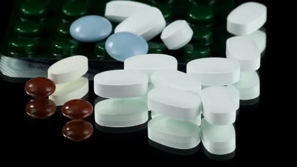 Białe tabletki na obrotowe czarne tło — Wideo stockowe