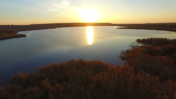 Bei Sonnenuntergang über den See fliegen — Stockvideo