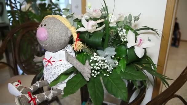 Muñeca con flores en la mesa — Vídeos de Stock