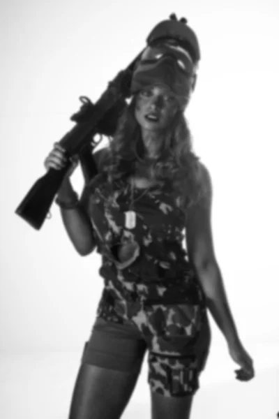 Woman in military uniform with a gun