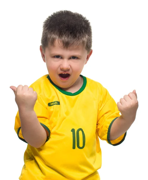 Pieni poika brasilialaisessa kansallisessa jalkapallopaidassa — kuvapankkivalokuva
