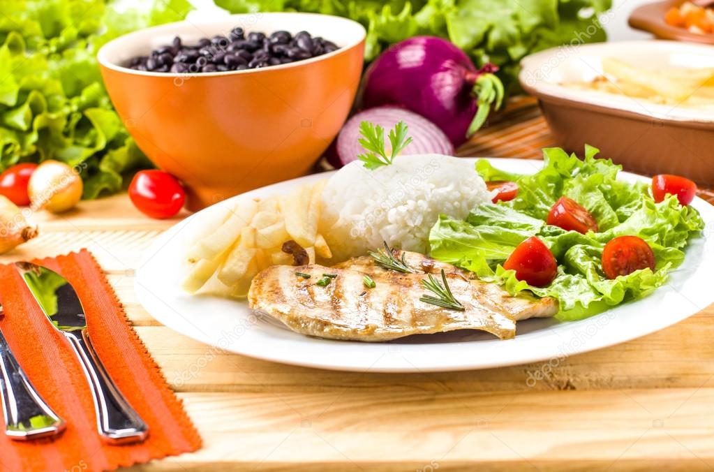 Grilled meat, rice and beans. — Stock Photo © diogoppr 69745081