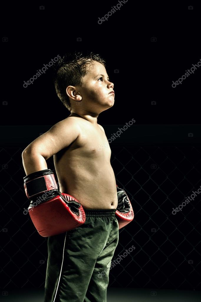 Child boxer in shorts and boxing gloves on hands Stock Photo by