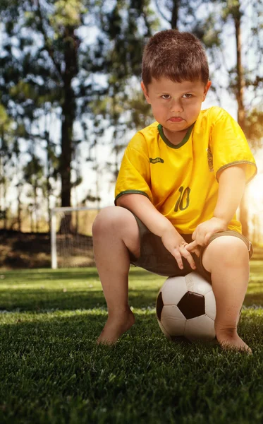 Boy v brazilské fotbalové tričko a míček — Stock fotografie