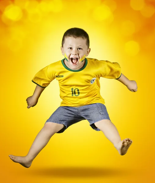 Poika brasilialaisessa jalkapallopaitassa — kuvapankkivalokuva