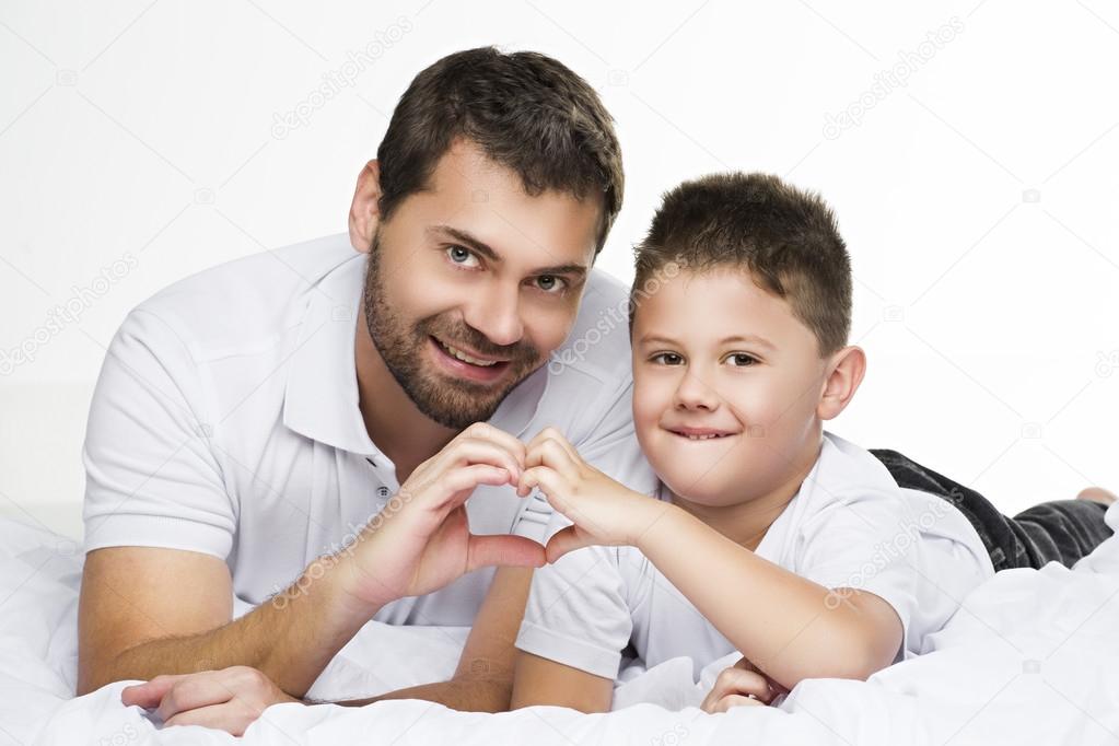 father and son making heart sign