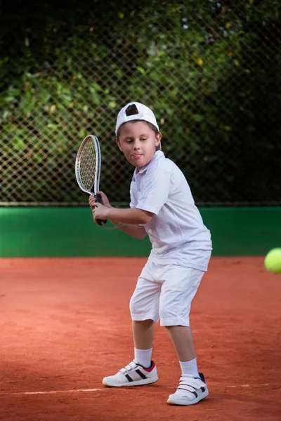 Mladý chlapec hraje tenis — Stock fotografie