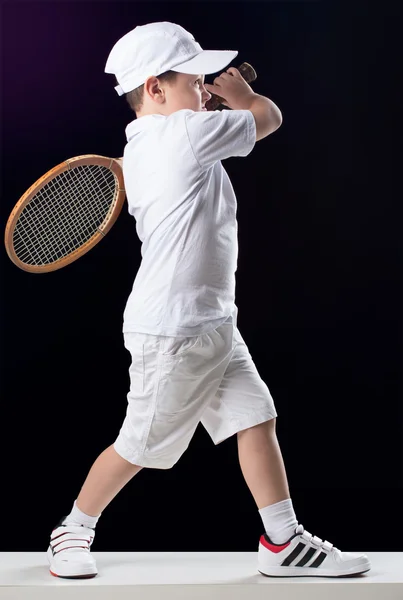 Мальчик с теннисной ракеткой в студии — стоковое фото