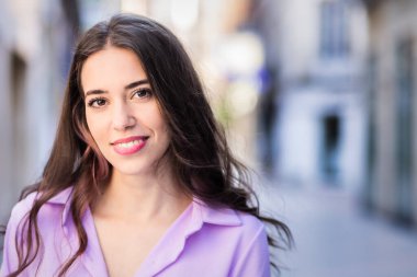 Güzel, İspanyol asıllı, bağımsız, genç bir kadın hayat tarzı, şehir portresi. Lavanta sokak kıyafetleri kameraya bakıyor. Gerçek insanlar.