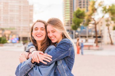Gündoğumunda lezbiyen ve etnik çeşitlilikte genç bir çift sarılıyor. Birlikte mutlu kız arkadaşlar 