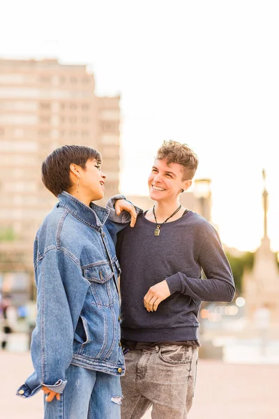 Jovem casal lésbico Tomboy. Androgynous transgênero não binário e uma mulher hispânica com cabelo curto — Fotografia de Stock