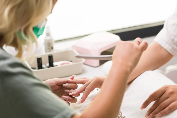 Nägel Maniküre Lifestyle Maniküre Maniküre in einem Salon. Junge lateinische Frau Handpflege Glasfaser-Behandlung — Stockfoto