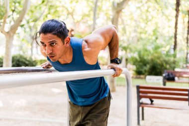 Venezuelalı engelli sporcu, açık hava jimnastik parkındaki paralel barlara dalış yaparak güç ve kararlılık gösteriyor.