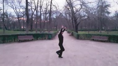 Yetenekli bir erkek flamenko dansçısının halk parkındaki bir yolda tutkuyla dans edişinin havadan görüntüsü. Kamera dans sırasında nazikçe yükselir.