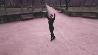 Tutkulu bir flamenko gösterisi yapan profesyonel bir erkek dansçının hava görüntüleri. Yalnız sanatçı zarif bir şekilde İspanya 'daki boş bir parka taşınıyor.