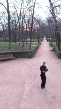 Yetenekli bir erkek dansçının havadan görünüşü. Sonbaharda bir şehir parkında geleneksel İspanyol flamenko dansı yapıyor.