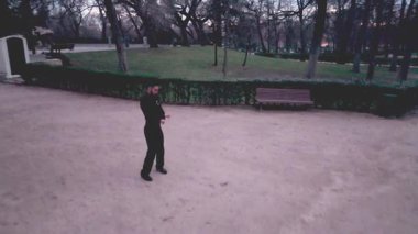 İspanya 'da güzel bir şehir parkında geleneksel flamenko adımları atan yetenekli bir erkek dansçının yüksek açılı perspektifi.