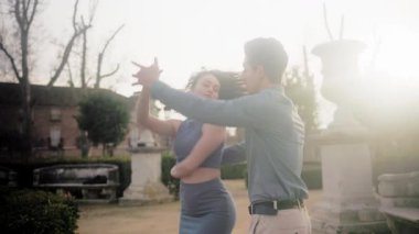 Genç tutkulu Latin çift açık havada şehvetli bachata dansı yapıyor. Güzel erkek ve kadın romantik bir anın tadını çıkarıyorlar.