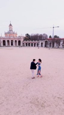 Tarihi bir İspanyol meydanında şehvetli bir bachata dansı yapan yetenekli bir çiftin hava görüntüsü. Profesyonel dansçılar tutkulu bir Latin ritmi uyguluyorlar.