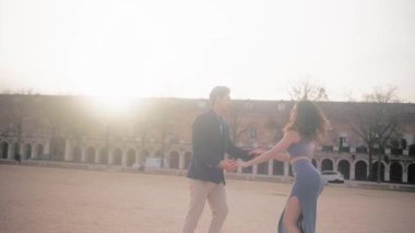 Tutkulu ve zarif bir çift, güzel bir Avrupa şehir meydanında şehvetli bir bachata dansı yapıyor.