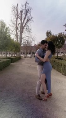 Güzel bir parkta şehvetli bir şekilde dans eden genç ve tutkulu bir çift. aranjuez, İspanya 'da gün batımında şehvetli Latince dans gösterisi