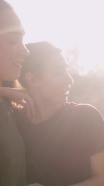 Birbirine aşık iki genç mutlu İspanyol kadın romantik bir anın tadını çıkarıyor. Gün batımında bir parkta el ele tutuşup gülüyorlar.