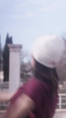 Modern bir şehir parkında hip hop dansı yapan dövmeli havalı bir genç kadın. Enerjik ve etkileyici sokak dansçısı tutkusunu ve yeteneğini gösteriyor.