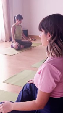 Güneşli bir yoga stüdyosunda meditasyon ve nefes egzersizi yapan çok kültürlü bir kadın grubu. Ruhani sağlık inzivası