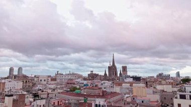 Barcelonas 'ın çatılarında uçan sinematik dron görüntüleri, bulutlu bir gökyüzüne karşı tarihi mimariyi ve katedrali gösteriyor.