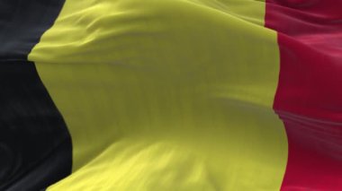 4k Belçika Ulusal bayrak kırışıklıkları mavi gökyüzü arka planında pürüzsüz rüzgar döngüsü.