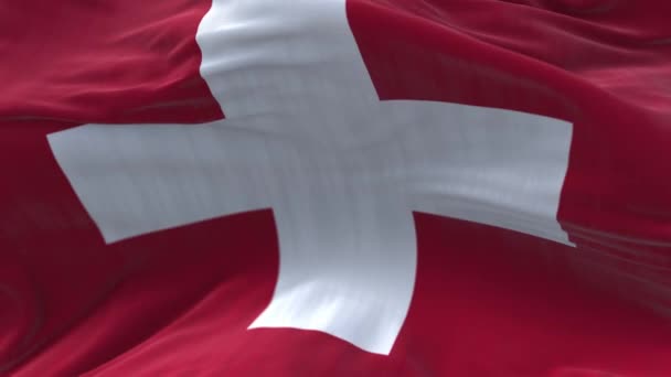 4k Schweiz National flagga rynkor loop sömlös vind i blå himmel bakgrund — Stockvideo