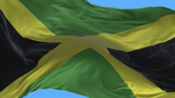4k Jamaica Nationale vlag rimpels lus naadloze wind in blauwe lucht achtergrond. — Stockvideo