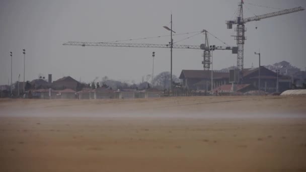 Vind blåser dimma över stranden, människor går på stranden mot hägring. — Stockvideo