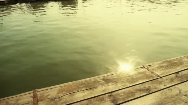 Волны на озерных и деревянных пирсах, отражение солнечного света в воде. — стоковое видео