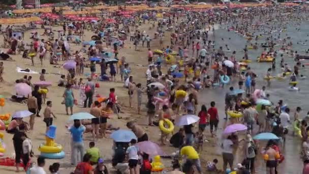 Mucha gente en la concurrida playa de arena de baño.La gente nada en el mar, Qingd de China — Vídeos de Stock