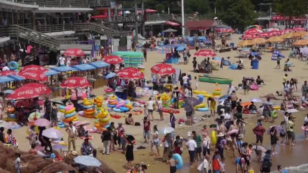 A lot of people at crowded bathing beach.China's Qingdao City.swim ring. — Stock Video