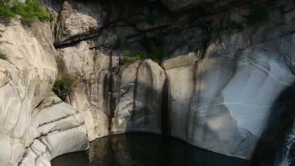 Bergwaterval beekje in zwembad van meerlagige steen, bossen en struiken. — Stockvideo