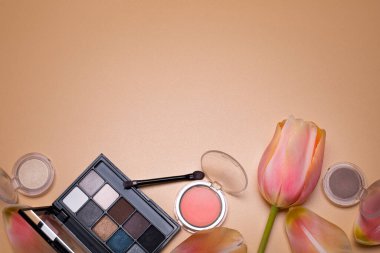 Makyaj ürünleri ve lale ile güzellik arka planı, metin için boş alan.