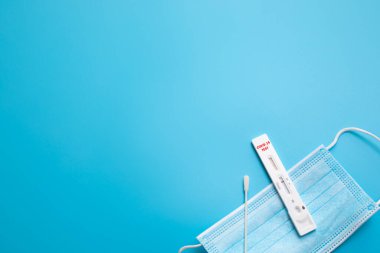 Mavi arka planda hızlı Coronavirus testi. COVID-19 için hızlı test cihazı kullanarak negatif test sonucu. Metin için boş alan.