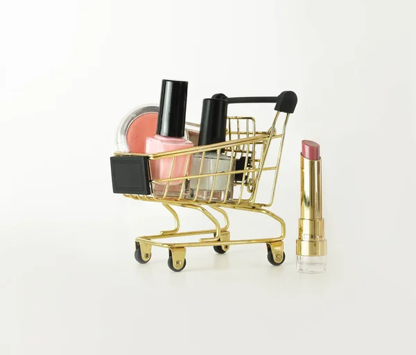 Chariot plein de maquillage et de produits cosmétiques sur fond blanc. Concept Black Friday. Vente et rabais. Marchandises pour femmes. Gros plan d'un panier avec des produits de maquillage. — Photo