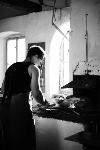 Le forgeron dans le processus de production de produits métalliques fabriqués à la main dans la forge. Photo noir et blanc — Photo