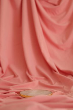 Pembe zemininde altın olan mermer bir podyum. Ürün podyumu, kozmetik sunumu. Yaratıcı bir model. Güzellik ürünleri için kaldırım taşı veya platform.