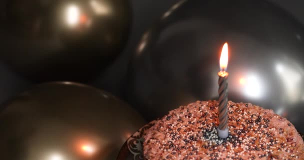 Zdmuchuję świeczkę. Tort urodzinowy ze świecą i balonami. Zbliżenie tortu imprezowego. Świętowanie — Wideo stockowe