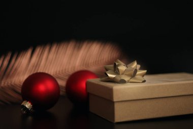 Noel kompozisyonu. Siyah arka planda hediye ve kırmızı süsleme. Modern Xmas arkaplanı.