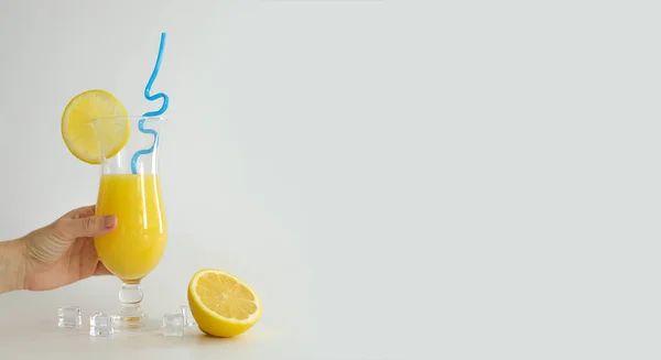 レモンと青の藁のスライスで飾られたガラスの新鮮なオレンジジュース。白い背景に夏のカクテル。カラフルなテンプレート。テキスト、コピースペースのための無料スペース. — ストック写真