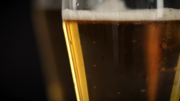 Two frosty glasses of cold golden beer with bubbles on the black background. Drinking alcohol on party, holidays, Oktoberfest or St. Patricks Day. — Stok Video